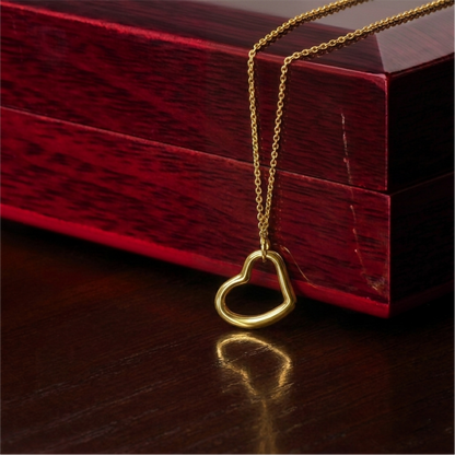Gold heart-shaped pendant necklace on a wooden surface